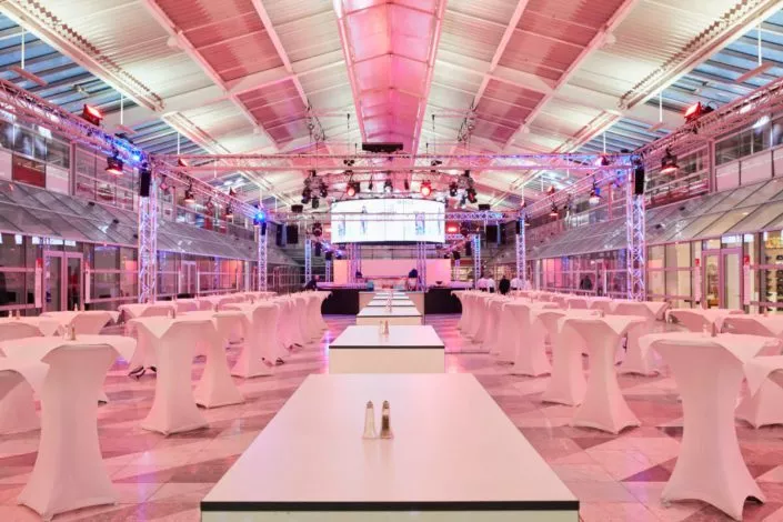 Bereich des Eventcenters MOC mit weißen Stehtischen als einfach erreichbares Ziel von unserem Hotel für Messen in München