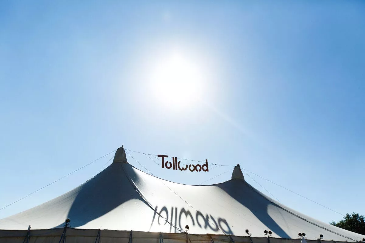 Ansicht Sommer Tollwood Zelt von Außen mit strahlend blauem Himmel und Sonne